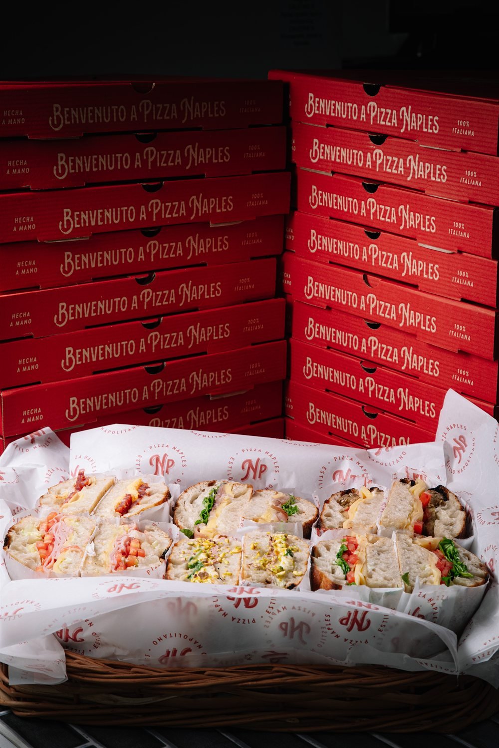 Producción Naples - cajas Pizza Naples apiladas y canasta de focaccias